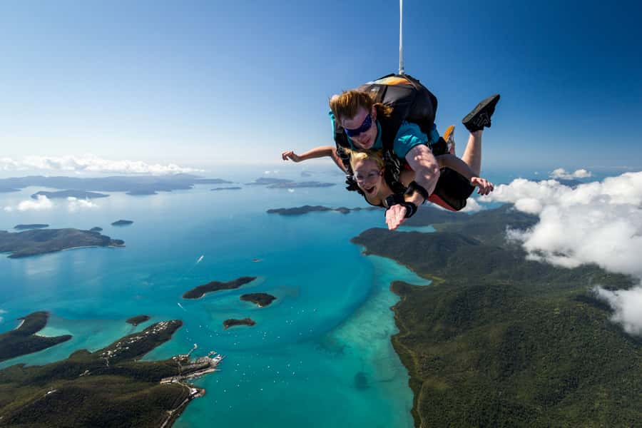 A tandem pair in freefall above the reef off Airlie Beach